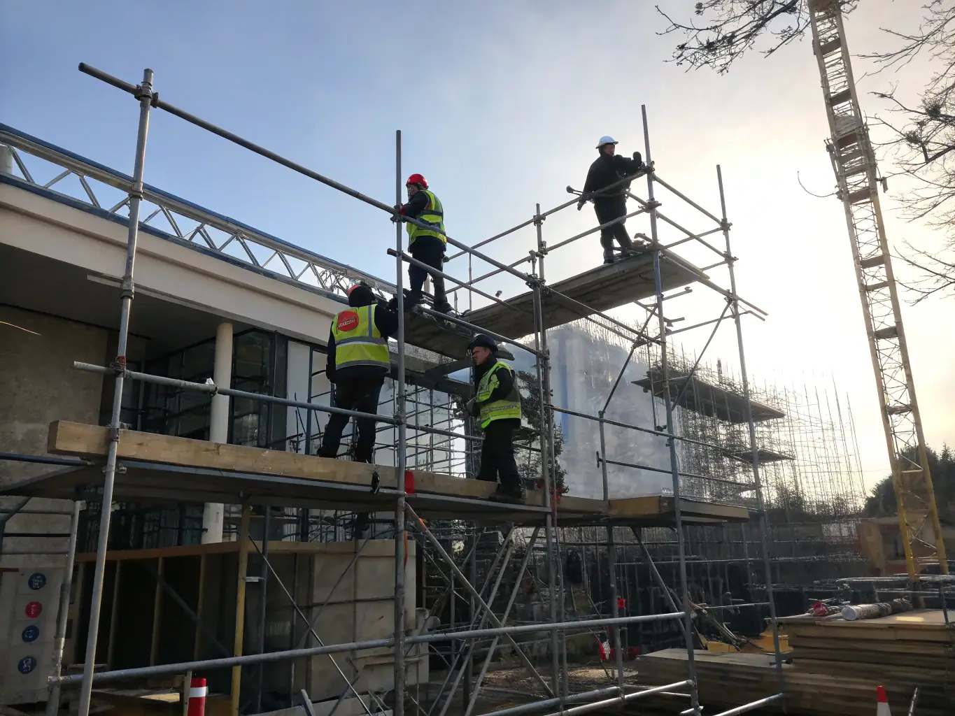 A photograph of workers installing expanded metal stair treads on a construction site. The image captures the ease of installation and the secure fit of the treads, highlighting the efficiency and safety of the process.