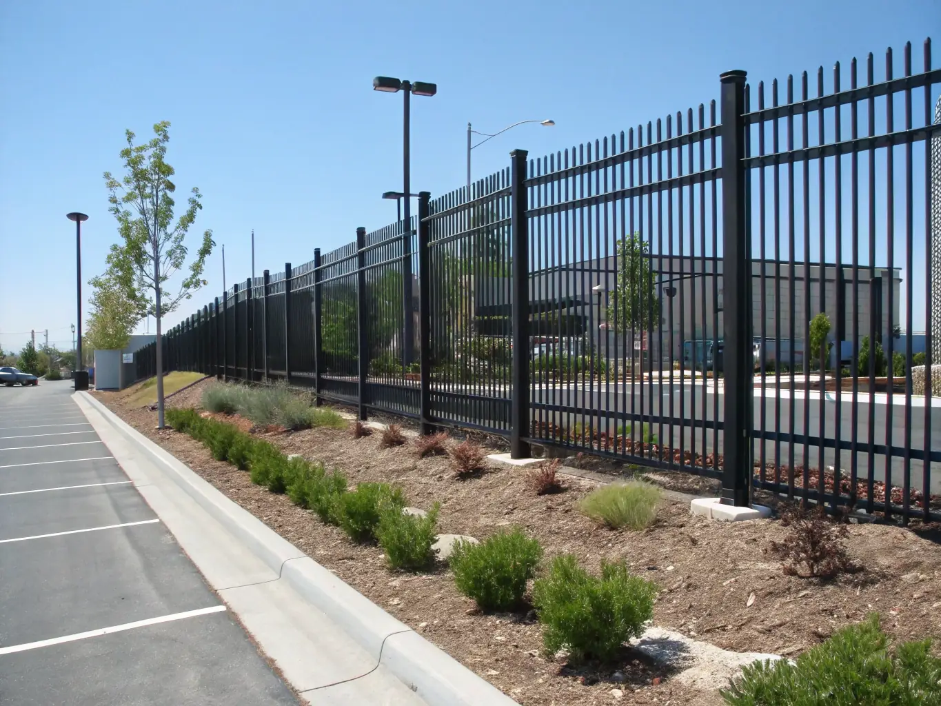 A high-resolution image showcasing a robust anti-climb fence surrounding a commercial property, emphasizing its tightly-knit mesh design and sturdy construction, set against a clear blue sky.