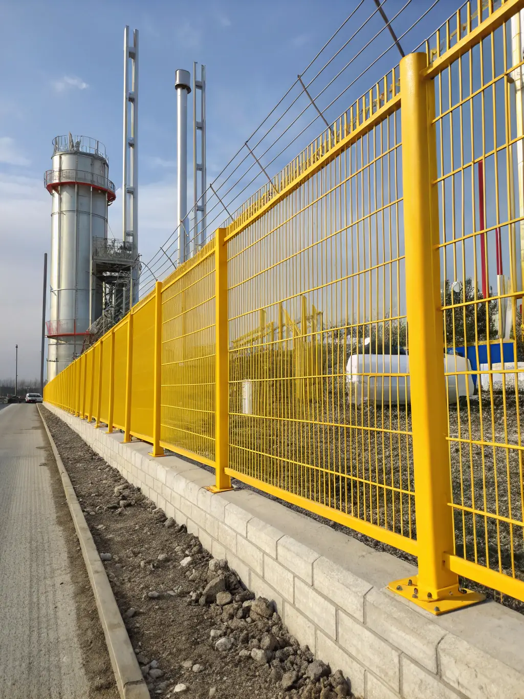 A panoramic view of industrial fencing installed around a manufacturing facility, emphasizing strength and security, used to represent the 'Fence' product category on the MutualMetal website.