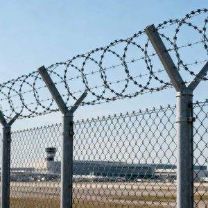 Airport perimeter protected by chain link fence with razor wire